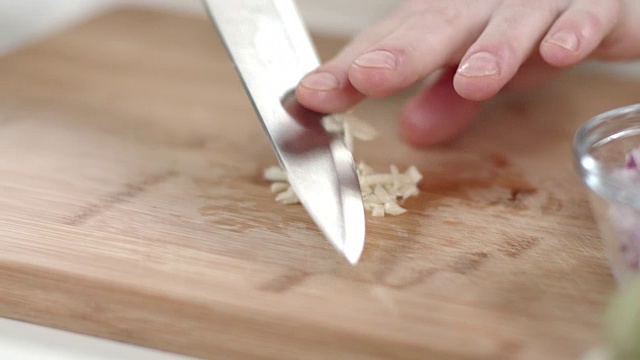 大厨用菜刀切碎蒜瓣的慢镜头视频素材