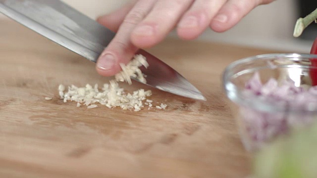 大厨用菜刀切碎蒜瓣的慢镜头视频素材