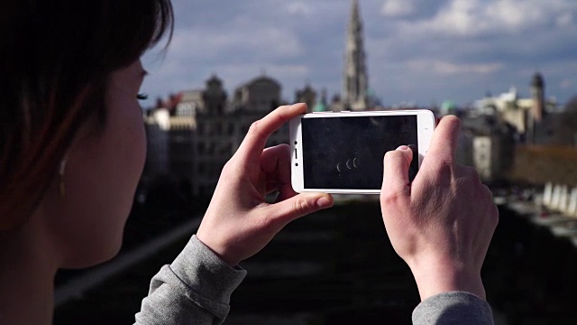 比利时布鲁塞尔，一名女游客用智能手机拍照视频素材