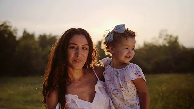 微笑的母亲和她的女儿在夏季公园视频素材