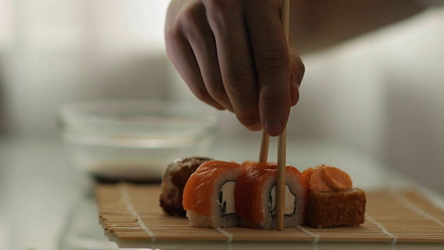 在一家日本餐厅吃午餐。男人吃寿司。视频素材