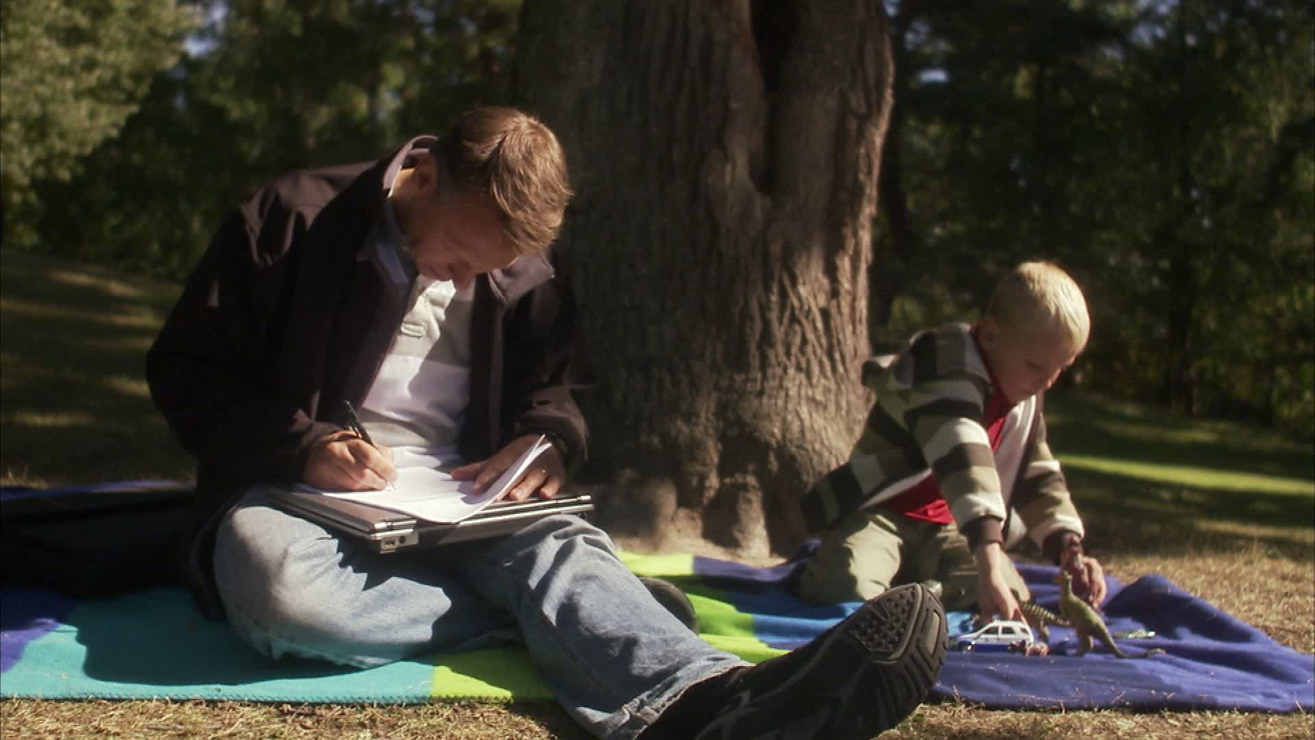 父亲和儿子在一个阳光明媚的一天瑞典的公园里。视频下载