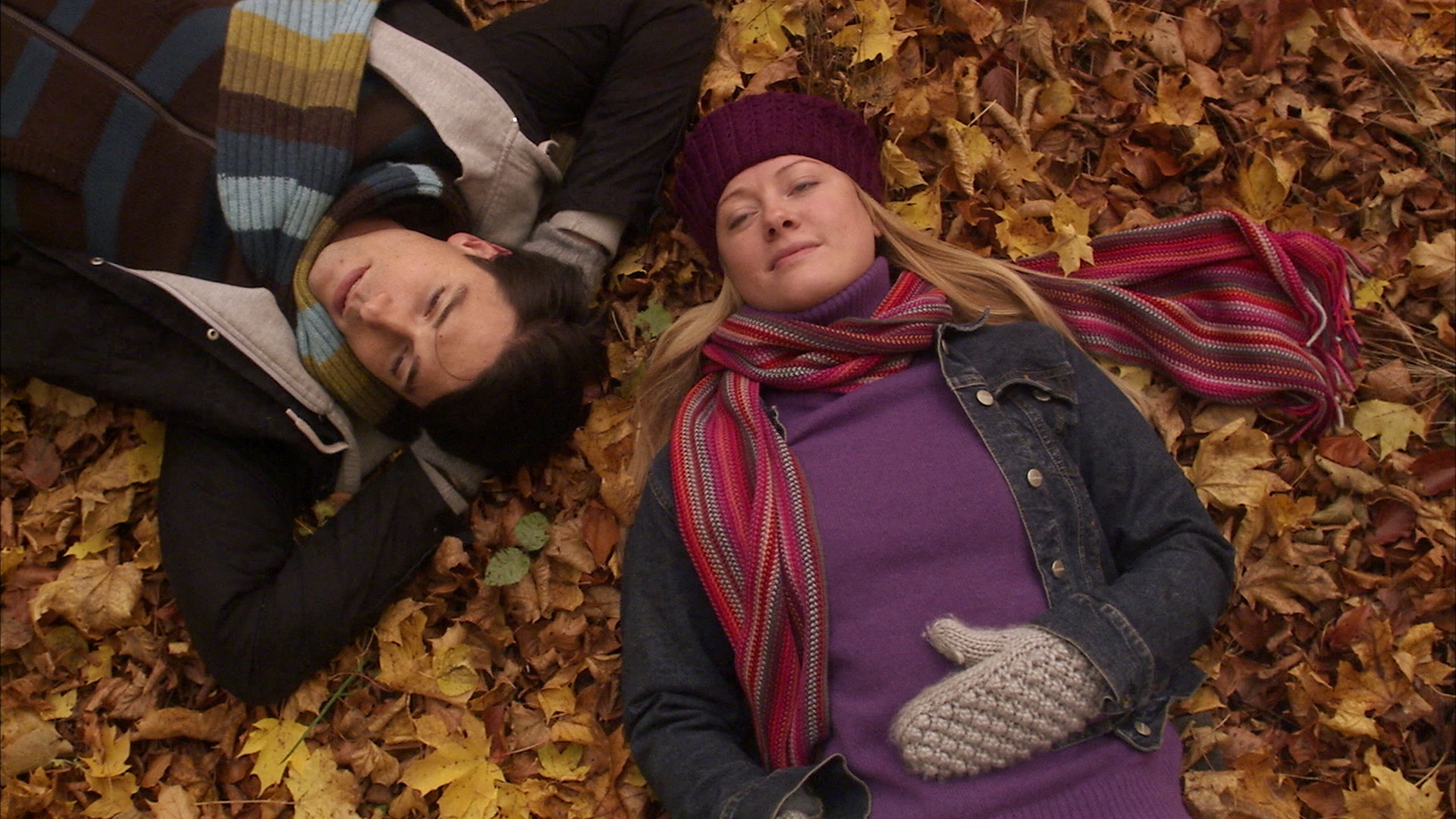一对夫妇躺在瑞典的秋叶上。视频素材