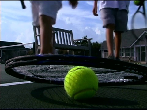 男孩子们坐在网球拍旁边的长凳上视频下载
