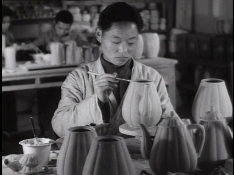 1944年，MS工人坐在工厂的长凳上制作瓷瓶，其他工人在后面/中国视频素材
