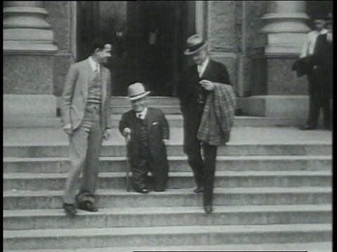 1931年2月5日，LS一名拄着拐杖与他人一起走出大楼并与他人握手的小个子男子，美国德克萨斯州奥斯汀视频下载