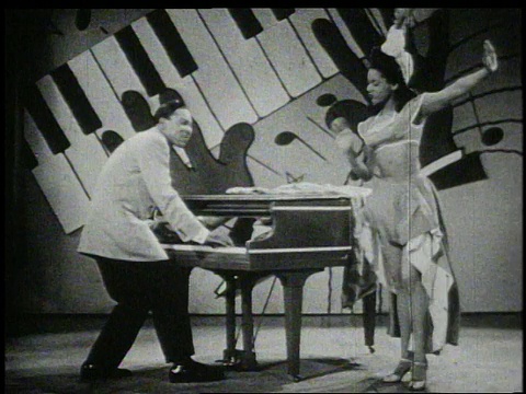 20世纪40年代，莫里斯·罗科一边弹钢琴一边唱歌，而一名女子在跳舞视频素材