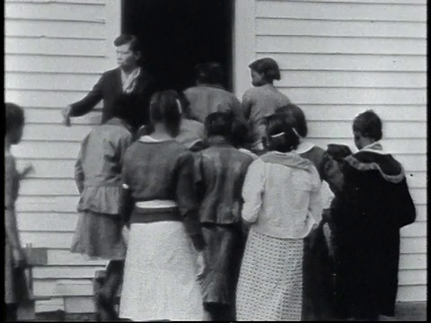 1940年，美国阿拉巴马州卡尔霍恩，WS学生重新回到学校，老师正站在门旁按铃视频素材
