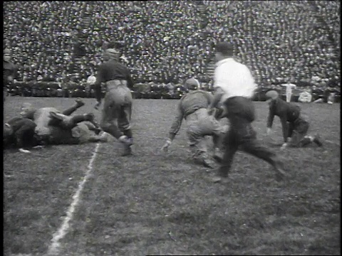 1925年WS美国，人们在球场上踢足球，在人群中奔跑视频素材