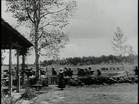 再现:美国马萨诸塞州康科德，一名妇女在她的农场里看着士兵们在土路上列队行进视频素材