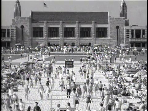 1947年，美国纽约琼斯海滩，HA人群在建筑物前挤来挤去视频素材