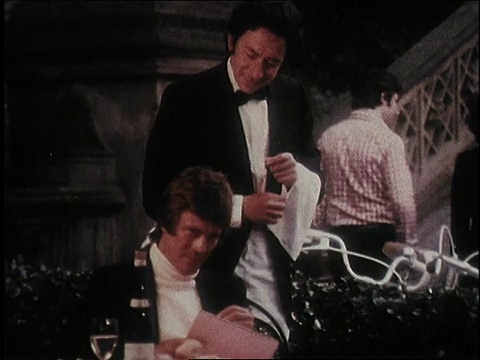1974蒙太奇男子坐在户外咖啡馆里为女子速写肖像，Soave Bolla Wine /美国视频下载