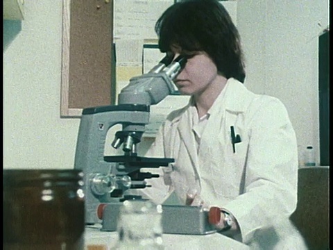1979蒙太奇医疗技术人员观察高倍显微镜/美国视频下载