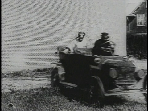 1920蒙太奇男子驾驶汽车旁边的电车，然后在潮湿的道路上打滑，倒车撞到砖墙视频下载
