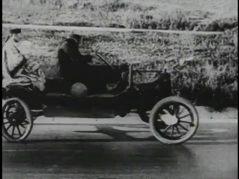 1920年，当各种零件脱落时，男人们在椭圆形轮子的破旧汽车里颠簸前行视频下载