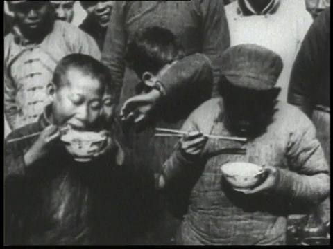 1932年WS儿童用盛有薯条的碗吃面条/中国视频下载