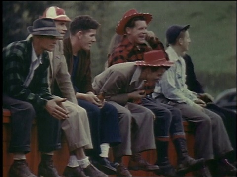 1957年，蒙太奇，年轻男子坐在一排东西上观看表演，舞台上有纹身的人，食火者，在力量机器上摇摆锤子的人的杂耍/比利时布鲁塞尔视频下载
