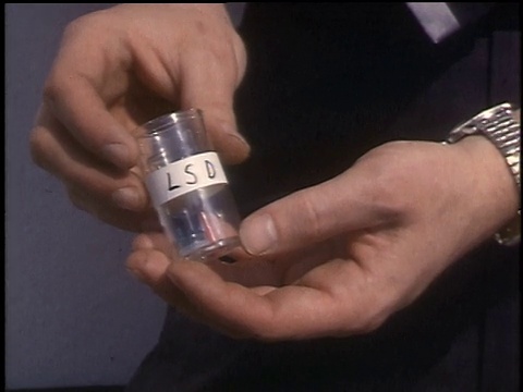 1968年，CU男子手持装有不同形式LSD的瓶子，并将它们倾倒在他的手上视频下载