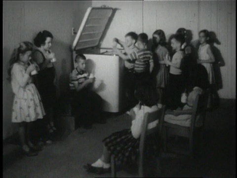 1950年，美国俄亥俄州韦恩，蒙太奇儿童在改装车库喝牛奶视频下载