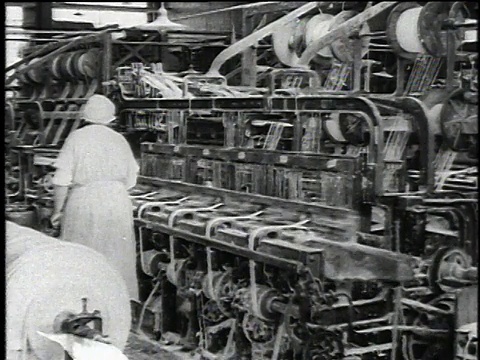 1921年，美国伊利诺斯州沃基根，蒙太奇工人操作生产石棉纱和刹车衬带堆的机器视频素材