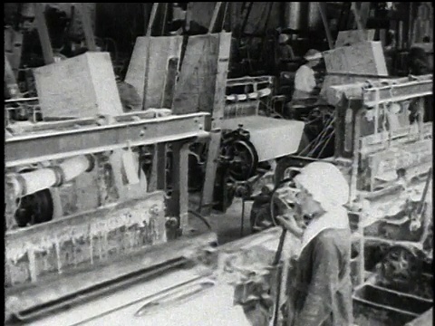 1921年，美国伊利诺斯州沃基根，蒙太奇织机在大房间中提炼石棉和工人操作机器视频素材