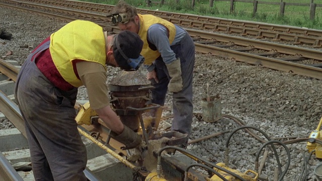 1969年，蒙太奇工人沿着英国铁路/英国的新轨道焊接组件视频下载