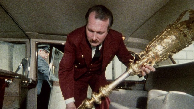1985蒙太奇一名管家将仪式用剑和权杖放入一辆汽车/伦敦，英国视频下载