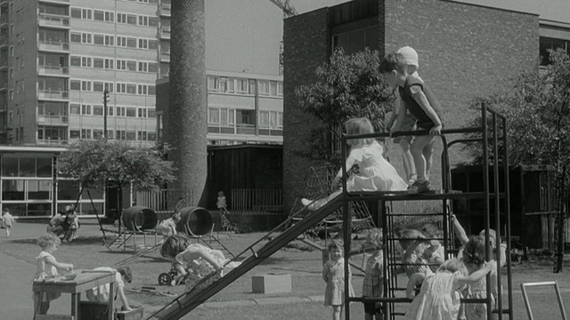 1960年，英国一所幼儿园的儿童在操场上玩水盆和画画视频素材