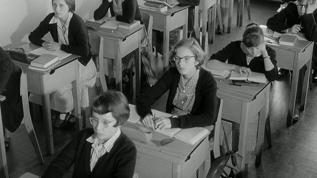 1960蒙太奇儿童在教室里听老师讲课/英国视频素材