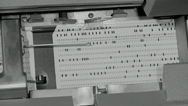 1969蒙太奇一间工业零件库存储藏室，和计算机技术人员输入数据指令和穿孔卡片机处理信息/联合王国视频下载