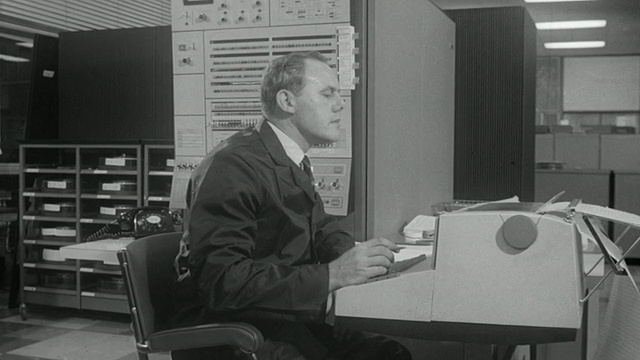 1969蒙太奇电脑技术人员加载磁带，按按钮，打字，调整纸张在打印机/英国视频下载