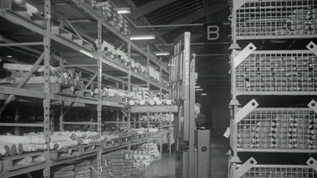 1969蒙太奇仓库，电脑操作员通过窗口将订单信息传递给工人，工人在地板上装货，推托盘和操作叉车/英国视频下载