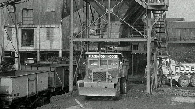 1954年，蒙太奇自卸卡车停在卡车后面，卡车驶出装卸区，行驶在布满车辙的丘陵地带，到达弃置区/英国阿克赖特视频下载