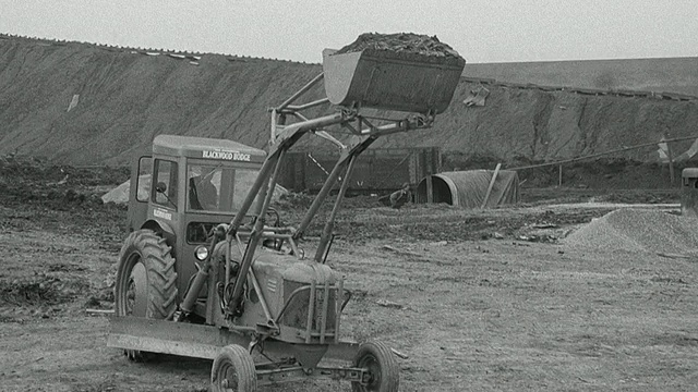 1954年，在性能测试期间，B/W前置装载机向自卸卡车倾倒泥土，英国阿克赖特视频素材