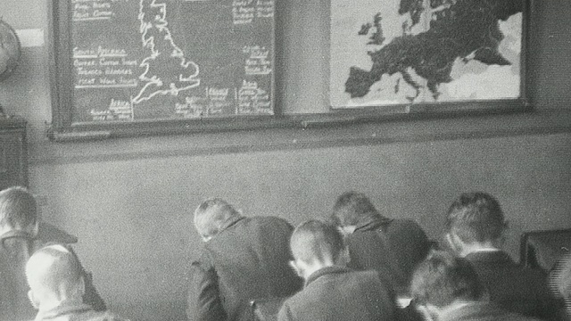 1925年，英国泰恩河畔纽卡斯尔，蒙太奇学生在教室里，老师教他们地理，计算圆柱体的体积，做木工作业视频下载