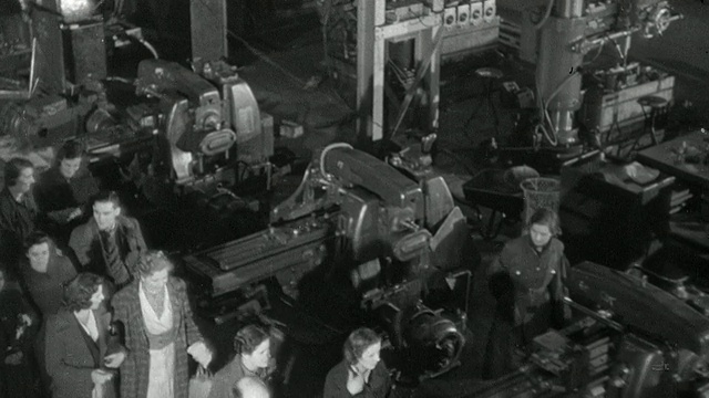 蒙太奇工人开始他们的轮班在一个工厂，主管收集工作订单从办公室和交付他们的工人，一个新工人正在展示如何操作机器，和各种机器在操作/英国视频素材
