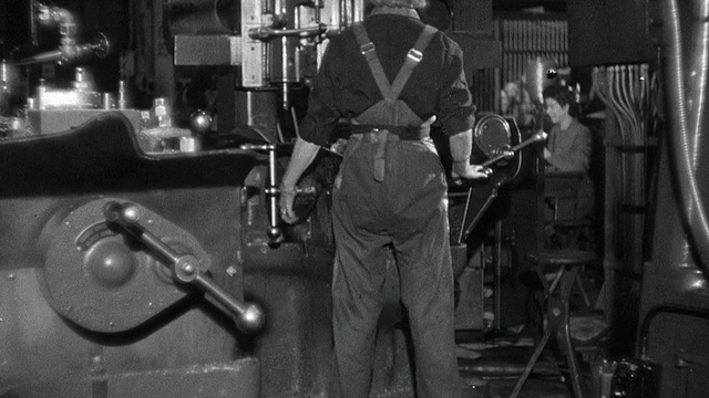 蒙太奇工厂工人在工厂内操作各种机器/英国视频素材