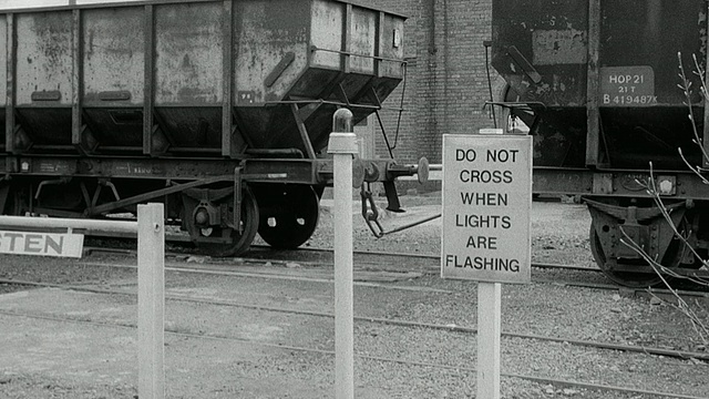 1969年，蒙太奇标志和煤炭沿着火车轨道移动的火车车厢/英国视频下载