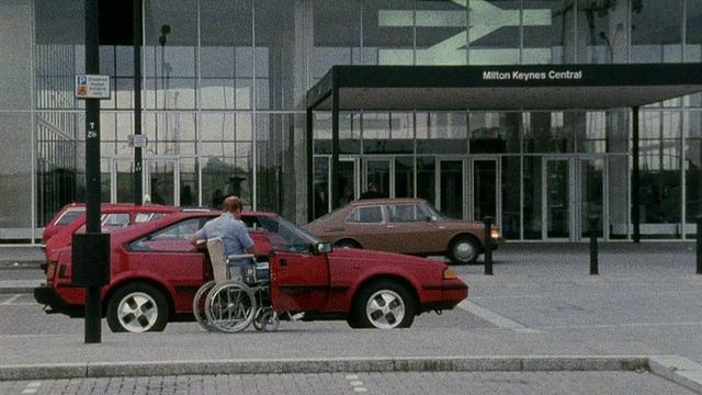 1978年，英国一位残疾人走出汽车，坐上轮椅，进入一栋大楼视频下载