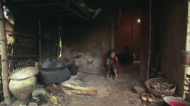 ZI村民在一个大锅下生火，然后把水舀进一个小锅里/越南巴利亚- vung头的巴湾视频下载