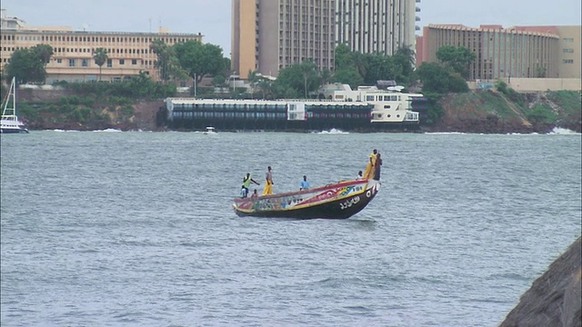 塞内加尔达喀尔，在城市天际线背后的划艇上的乘客视频下载
