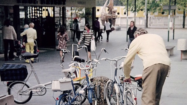 1974年，蒙太奇骑手从停车场和露天市场广场的架子上拆卸自行车/英国视频下载