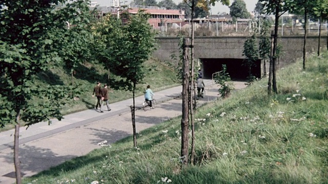 1974年，在英国，市民们骑着自行车在城市各处，在隧道下，在小径上，在自行车道的桥下视频下载