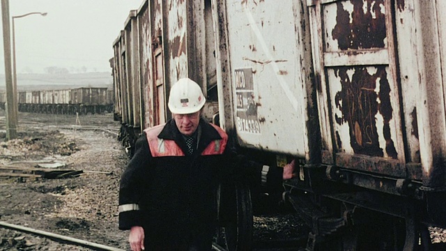 1980年蒙太奇煤车在煤场称重，铁路工人检查火车，火车旁边的显著数字/英国视频素材