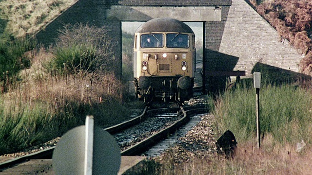 1980蒙太奇煤火车缓慢移动，通过小拱桥/英国视频素材
