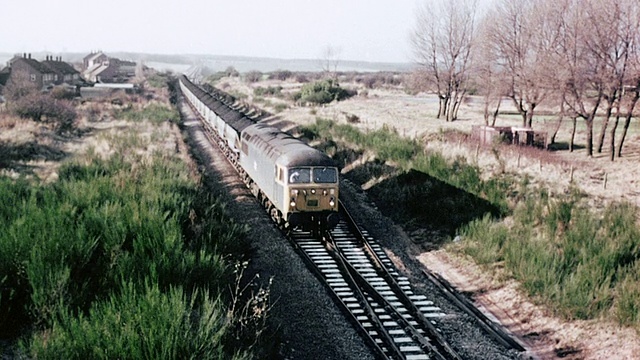1980蒙太奇煤炭火车在轨道上缓慢行驶，然后加速，穿过一座桥，在桥下倒影视频素材