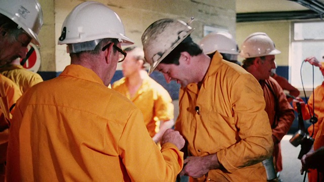 蒙太奇经理们穿着橙色工作服穿过矿区，准备进入地下/英国视频下载