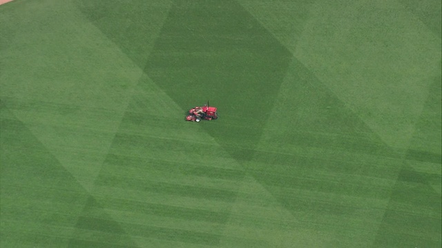 AERIAL大型红色草坪割草机在美国马萨诸塞州波士顿的芬威棒球场修剪草坪视频下载