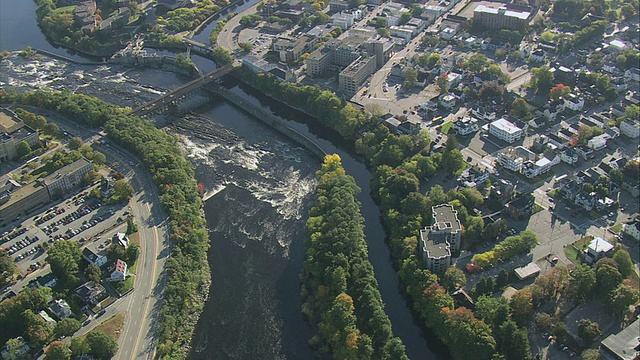 梅里马克河上的波塔克特瀑布下面的空中急流，沿着河岸和横跨美国马萨诸塞州洛厄尔的桥梁排列的小城市视频下载