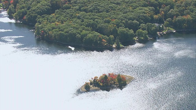 空中的秋色森林，面对着河边的避暑小屋和船屋/美国马萨诸塞州视频下载
